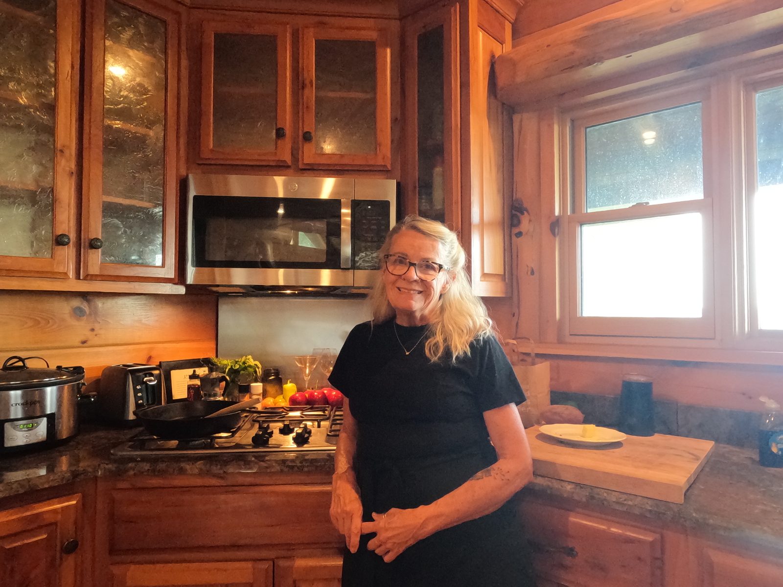 Carol standing at her stove in her kitchen, a cast iron skillet on the burner beside her